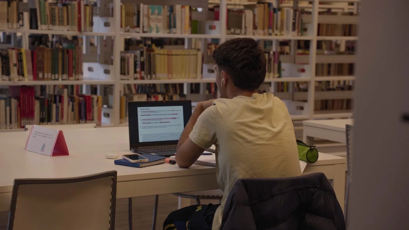 Estudiante estudiando en una biblioteca de la UDELAR